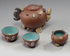 A Chinese yixing 'fruit and nut' teapot, a 'fruit and nut' cup and a pair of enamelled yixing cups