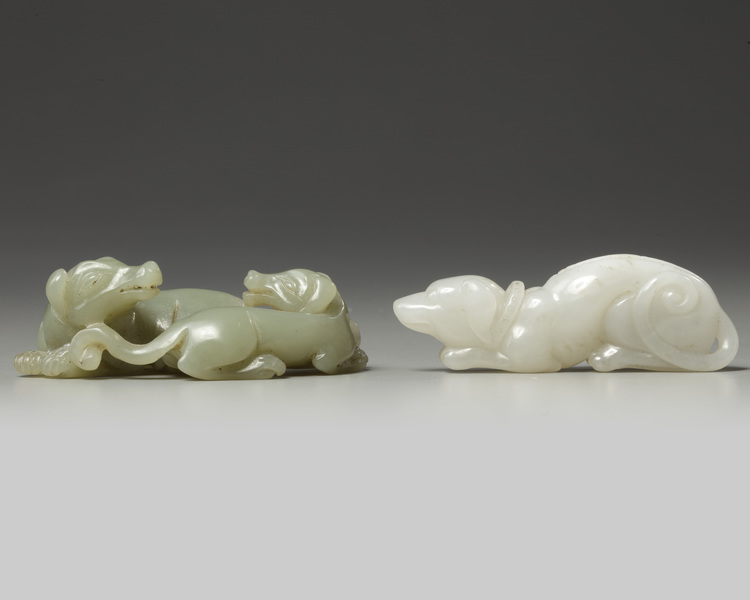 A Chinese white agate dog carving and a celadon jade twin dog carving