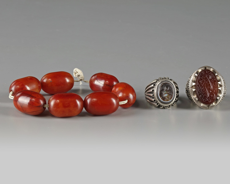 Two silver rings and an amber bracelet