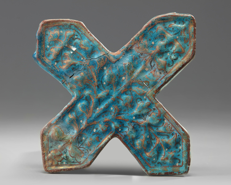An Islamic turquoise cross shaped tile