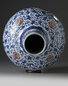 A Chinese blue and white and underglaze copper red-decorated ‘flower scroll’ bottle vase