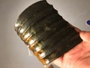 A Chinese Hongshan-style spinach and russet jade comb-shaped accessory