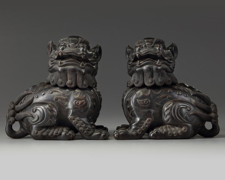 A pair of Chinese carved zitan wood Buddhist lions