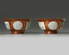 A pair of Chinese coral-ground famille rose 'Tilling and Weaving' bowls