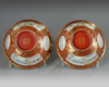 A pair of Chinese coral-ground famille rose 'Tilling and Weaving' bowls