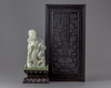 A pale jade carving of a guanyin in a zitan box and stand