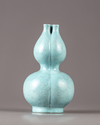 A Chinese celadon-ground white-enamel-decorated conjoined triple-neck double-gourd vase