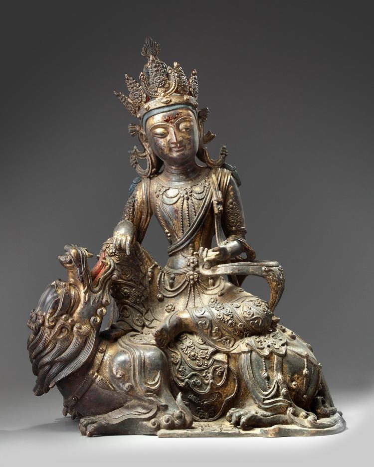 A bronze figure of guanyin seated on a mythical beast