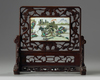 A Chinese famille verte plaque inset into a wooden table screen