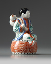 A JAPANESE FIGURE OF A BOY ON A DRUM, 1670-1690