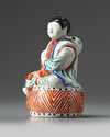A JAPANESE FIGURE OF A BOY ON A DRUM, 1670-1690
