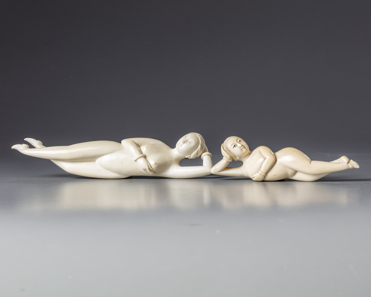 Two Chinese carved ivory reclining figures