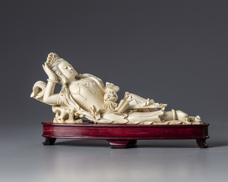 An ivory carving of a reclining Guanyin holding a ruyi sceptre
