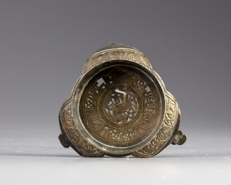 An Islamic bronze lamp stand