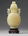A Chinese pale celadon jade 'taotie' vase and cover