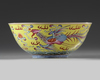 A Chinese yellow ground famille rose 'dragon and phoenix' bowl