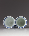 Two blue and white stemmed beakers