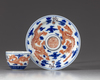 A small Chinese iron-red-decorated blue and white 'dragon' cup and saucer
