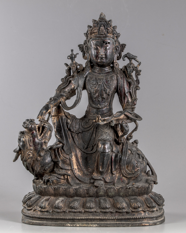 A partial gilt and lacquered figure of guanyin on a mythical beast