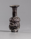 A ROMAN MOULDED PURPLE GLASS HEAD FLASK, CIRCA 3RD CENTURY AD