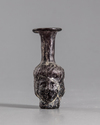 A ROMAN MOULDED PURPLE GLASS HEAD FLASK, CIRCA 3RD CENTURY AD