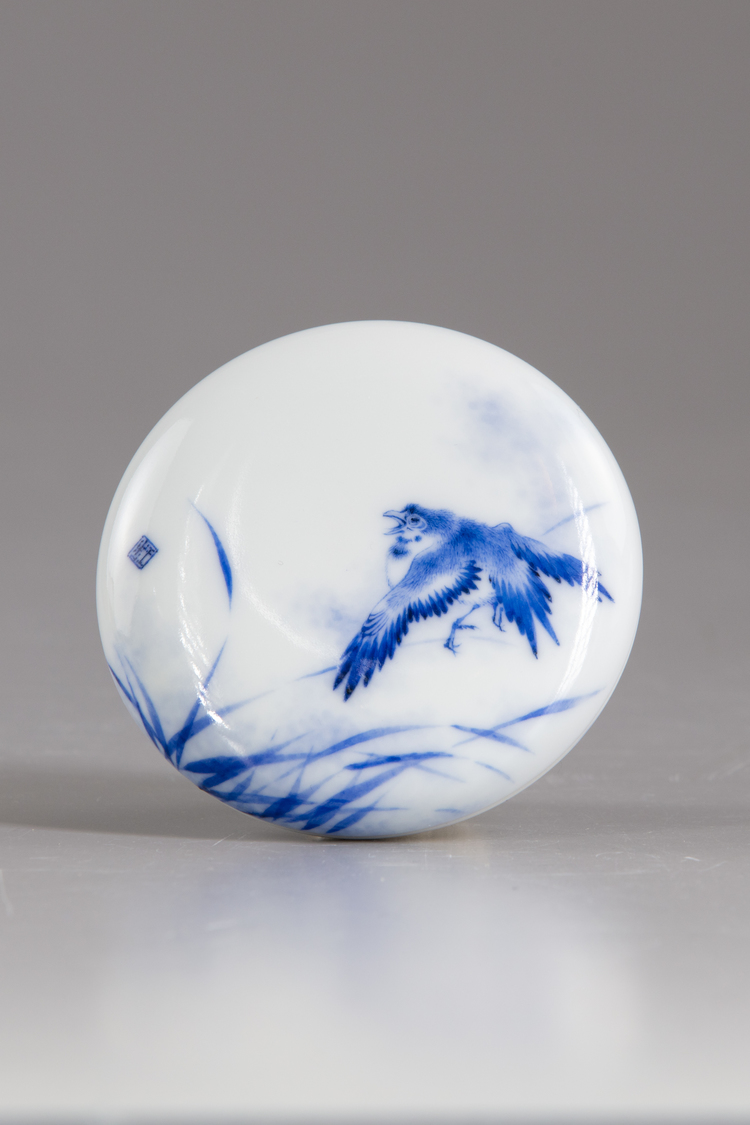 A blue and white circular paste box and cover