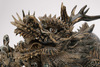 A ceramic figure of a dragon resting on its claws  and a wide open mouth and inlayed eyes