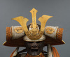 A large gilded Japanese ōyoroi with orange cords (hi’ito odoshi yoroi). A large hoshikabuto-helmet with gilded parts, large fukikaeshi