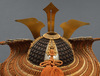 A large gilded Japanese ōyoroi with orange cords (hi’ito odoshi yoroi). A large hoshikabuto-helmet with gilded parts, large fukikaeshi
