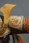 A large gilded Japanese ōyoroi with orange cords (hi’ito odoshi yoroi). A large hoshikabuto-helmet with gilded parts, large fukikaeshi