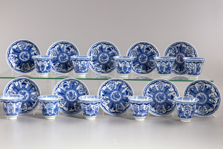 A group of eleven blue and white saucers and ten cups