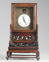 A Chinese gilt bronze table clock in a hongmu case and stand