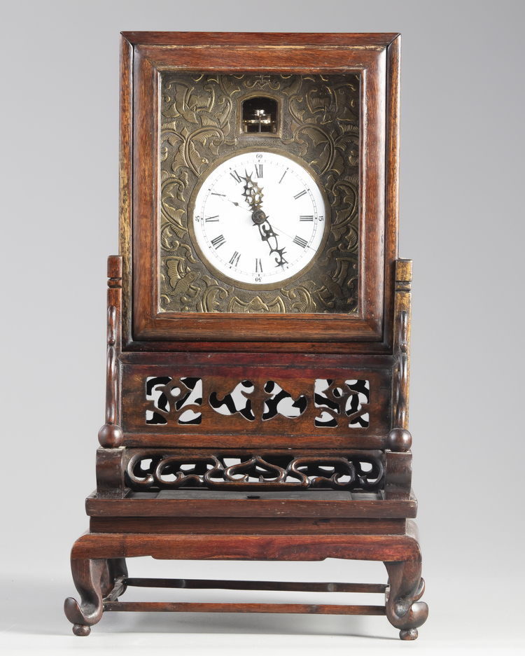 A Chinese gilt bronze table clock in a hongmu case and stand