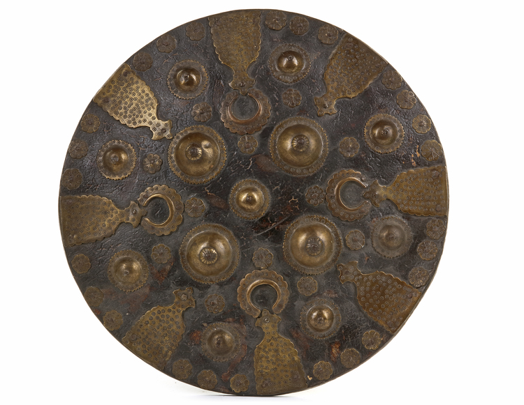 A MUGHAL BRASS AND LEATHER SHIELD, 17TH-18TH CENTURY