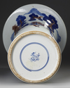 A CHINESE UNDERGLAZE BLUE, COPPER-RED AND CELADON-GLAZED CARVED BEAKER VASE, GU