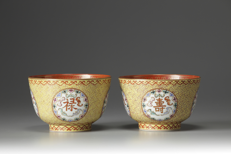 A pair of coral-red and yellow ground bowls with famille rose decoration