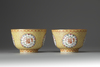 A pair of coral-red and yellow ground bowls with famille rose decoration