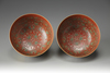A pair of coral-red and yellow ground bowls with famille rose decoration