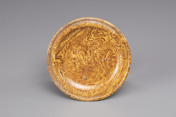 An earthenware marble-glazed dish on three small feet