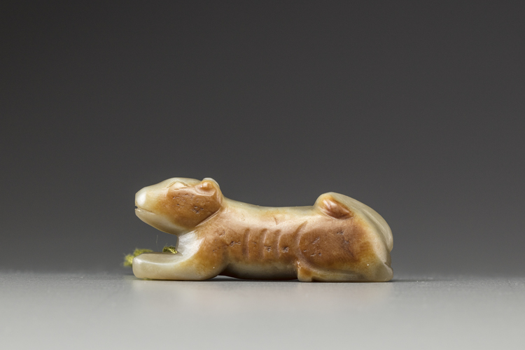 A celadon and russet jade carving of a hound
