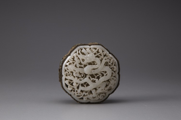 A white jade 'dragon' plaque inset into a gilt filigree box
