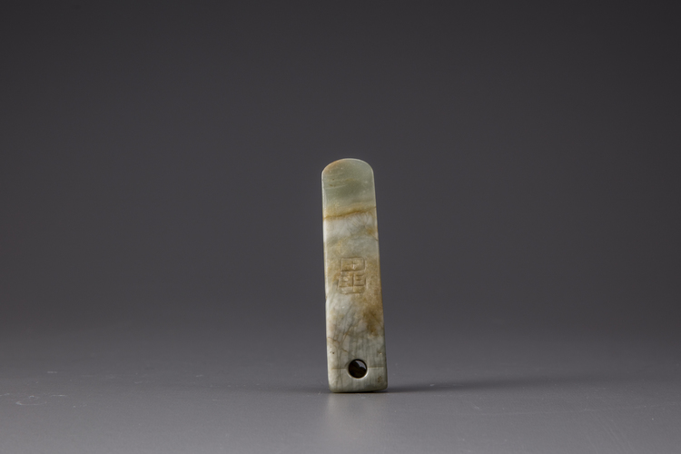 A celadon and russet jade hand tool