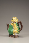 A moulded yellow, green, and aubergine-glazed teapot