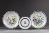 Three Chinese plates and four sets of blue-ground famille rose cups and saucers