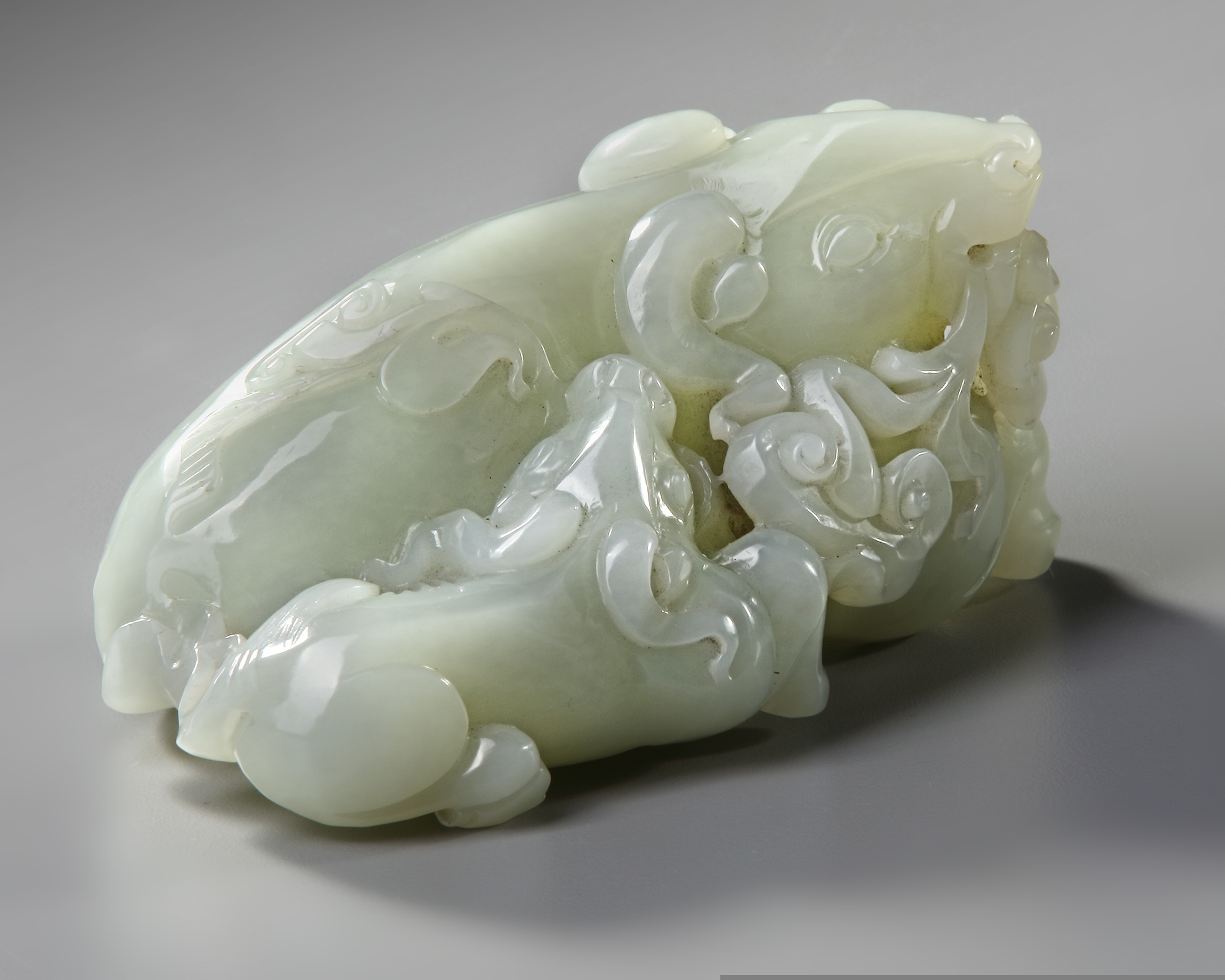 A CHINESE CELADON JADE CARVING OF A WATER BUFFALO GROUP, 19TH-20TH CENTURY