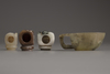 Three Chinese jade and agate 'hand'-shaped pipe bowl holders and a carved hardstone coupe