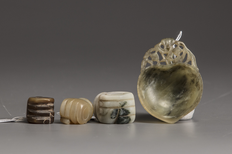 Three Chinese jade and agate 'hand'-shaped pipe bowl holders and a carved hardstone coupe