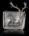 AN ACHAEMENID SILVER PLAQUE WITH SEATED STAG, CIRCA 550-500 B.C.
