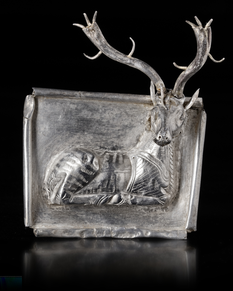 AN ACHAEMENID SILVER PLAQUE WITH SEATED STAG, CIRCA 550-500 B.C.