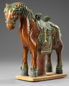 A CHINESE GREEN AND BROWN  GLAZED HORSE, MING DYNASTY (1368-1644 AD)